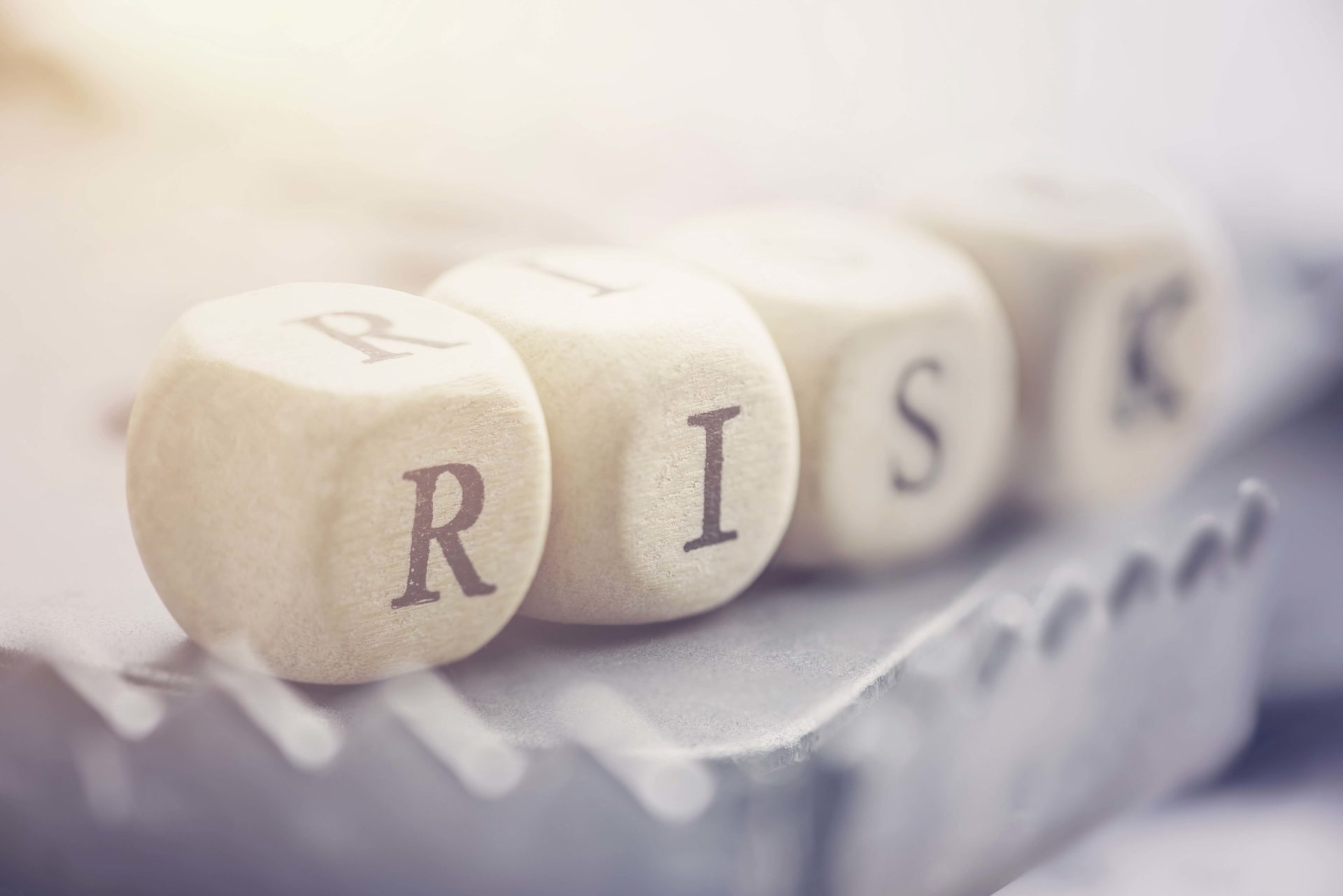 Four dices are arranged in a word "RISK" on a rat trap. Risk involves the chance an investment's actual return will differ from expected return, includes possibility of losing of original investment.