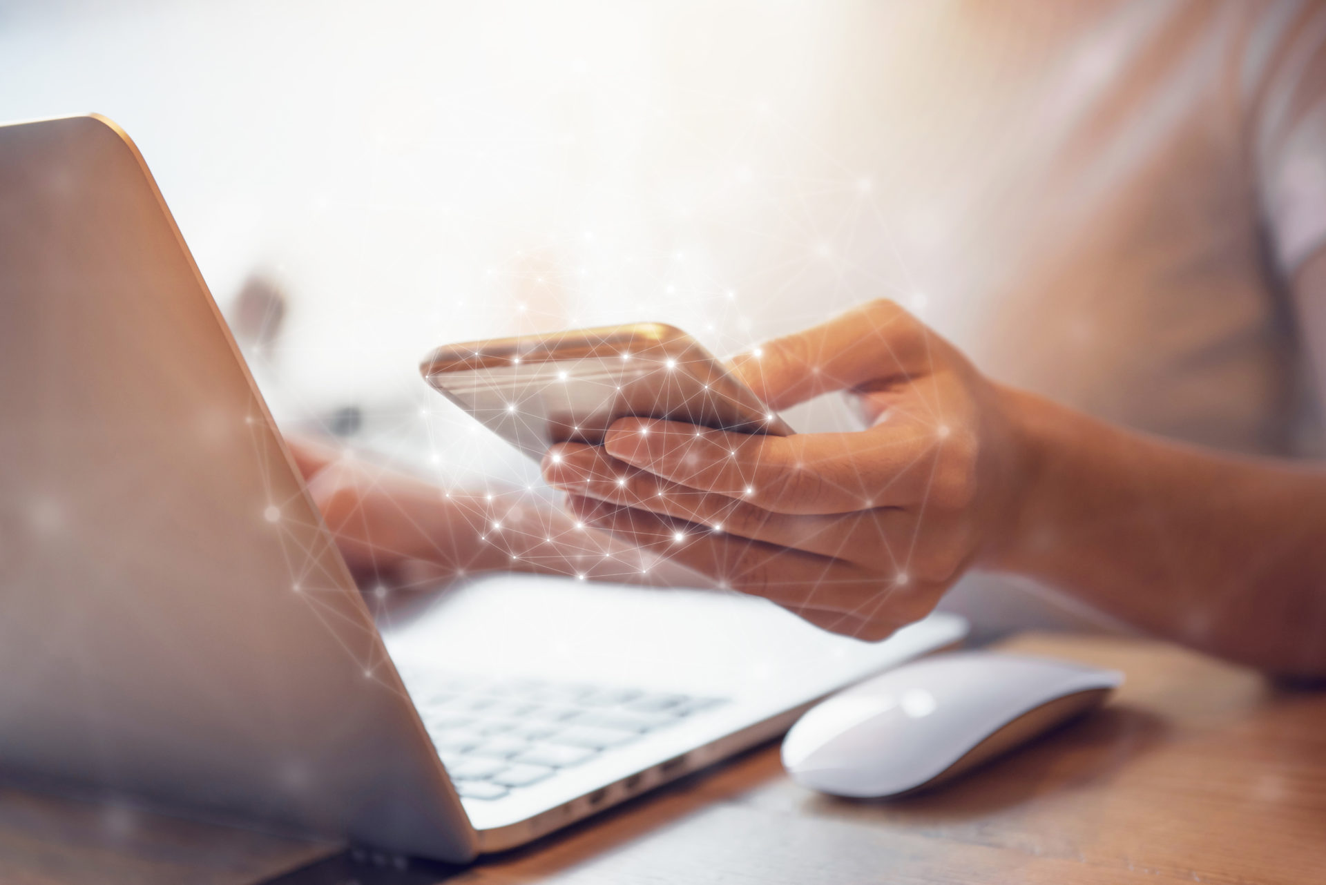Woman hand holding mobile phone and laptop data synchronization device at co-working office, She using in mobile applications and multimedia programs.