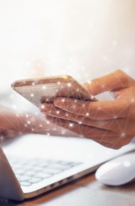 Woman hand holding mobile phone and laptop data synchronization device at co-working office, She using in mobile applications and multimedia programs.